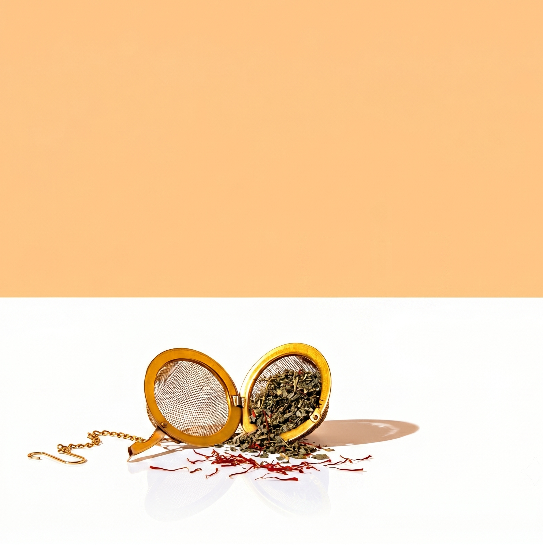 Tea infuser with loose tea on a white surface with a peach-colored background